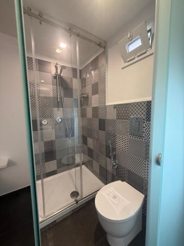 a bathroom with a toilet and a glass shower at Alley House in Cefalù