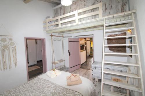 a bedroom with a bunk bed with a ladder at Casinha das Portas Amarelas in Monsaraz