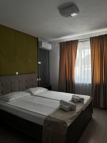 a bedroom with a bed with two towels on it at Vila Adelin in Tăşnad
