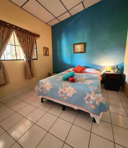 a bedroom with a bed with flowers on it at GuacamayaGuestHouse in Concepción de Ataco