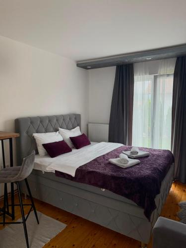a bedroom with a large bed with red pillows at Apartman Ena in Nova Varoš