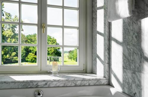 a bathroom window with a vase on a bath tub at SCHLOSS Fleesensee in Göhren-Lebbin