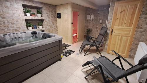 a large bathroom with a tub and chairs in it at Dom Wczasowy U Góralki in Murzasichle