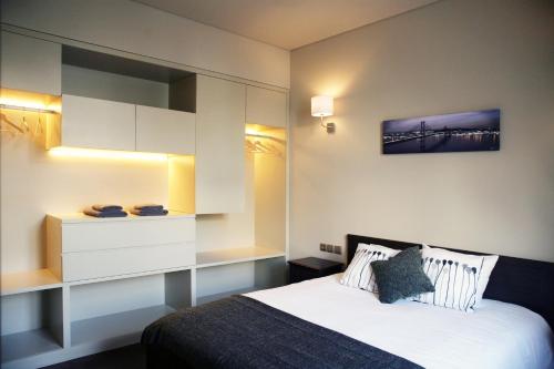 - une chambre avec un grand lit et une armoire blanche dans l'établissement Mercado da Ribeira 5 Stars Apartment, à Lisbonne