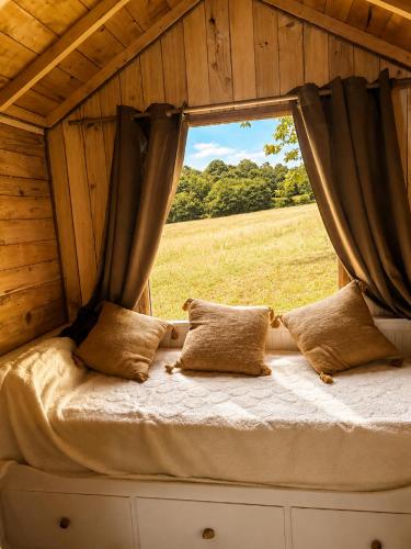 a bed in a room with a window at Tiny house a la ferme in Huelgoat