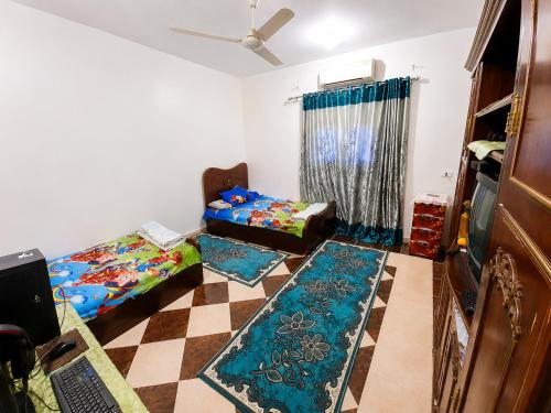 a living room with two beds and rugs on the floor at The Blue House in Safaga