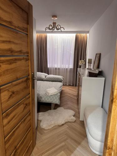 a room with a door and a chair and a window at Apartament Piękna in Łomża