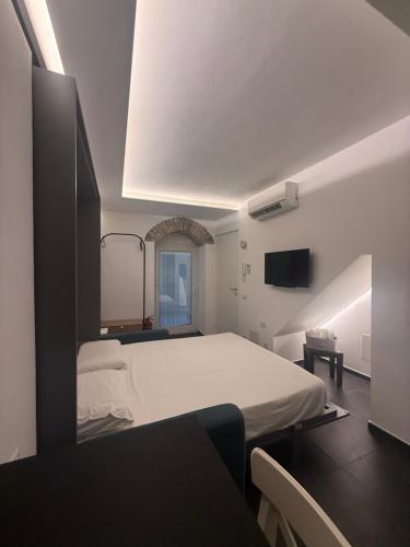 a bedroom with a large white bed and a window at Alley House in Cefalù