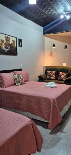a room with two beds and a couch at Aconchego I - Centro in Miguel Pereira