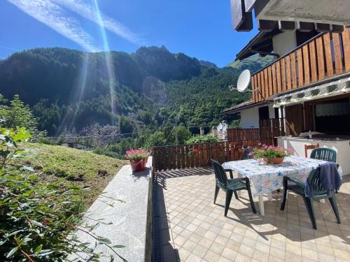 a patio with a table and chairs and a mountain at Maison au Soleil in Valtournenche