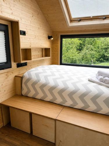 a bed in a room with a large window at Tiny House Luc in Prato Carnico