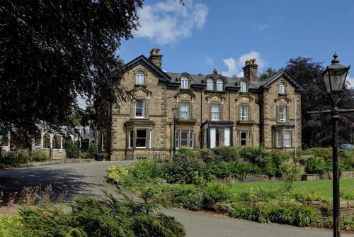 an old house with a street light in front of it at B/W Plus Buxton Lee Wood Hotel in Buxton