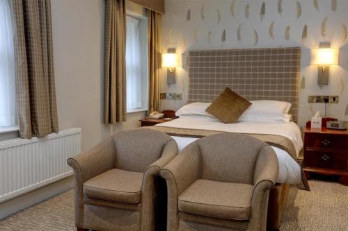 a hotel room with a bed and two chairs at B/W Plus Buxton Lee Wood Hotel in Buxton