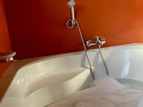 eine Badewanne mit Wasserhahn im Badezimmer in der Unterkunft Gee Heights Private Boutique Guest House in Thabazimbi