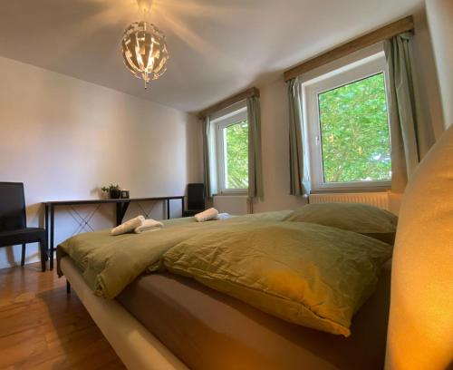 a bedroom with a bed and two windows at Wunderhaus am Goitzschesee in Bitterfeld