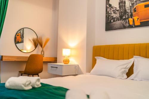 a bedroom with a bed and a chair and a mirror at Apartament23 Sibiu in Şelimbăr