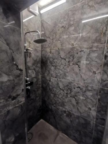 a bathroom with a shower with a stone wall at PRISHTINA Stay in Prishtinë