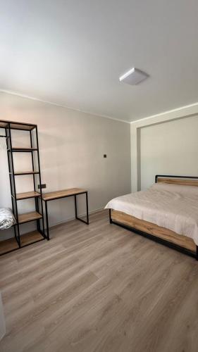 a bedroom with a bed and a book shelf at Aydin Guest House in Bayetovka