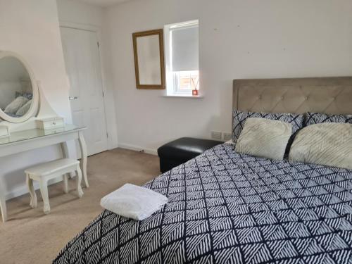 a bedroom with a bed and a desk and a mirror at FV Dwelling in Hucknall