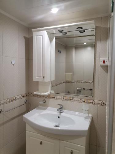 a bathroom with a white sink and a mirror at Апартамент Граф Игнатиев in Varna City