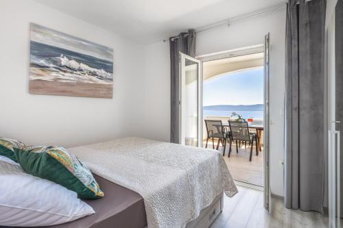 a bedroom with a bed and a view of the ocean at White Cove Apartments in Lokva Rogoznica