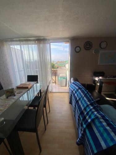 a living room with a table and chairs and a view at Comfortable apartment steps from Portal Belloto in Quilpué
