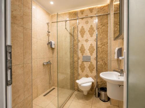 a bathroom with a shower and a toilet and a sink at mood beach hotel in Didim