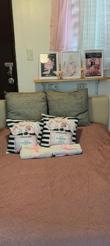 a bed with a bunch of pillows on it at Rooms in Bloom in Tarlac