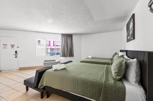 a bedroom with a green bed and a window at Travelsuites Hotel in Las Vegas