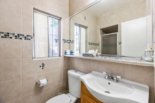 a bathroom with a sink and a toilet and a mirror at Travelsuites Hotel in Las Vegas