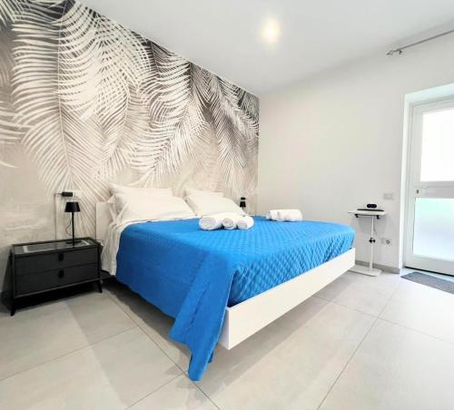 a bedroom with a blue bed with a mural at La Pola House Cagliari in Cagliari