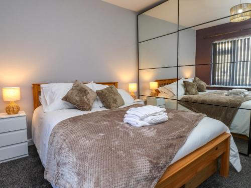a bedroom with two beds and a large mirror at Ger y Mynydd, 2 Cae Ty Coch in Brynteg