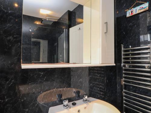 a bathroom with a sink and a mirror at Ger y Mynydd, 2 Cae Ty Coch in Brynteg