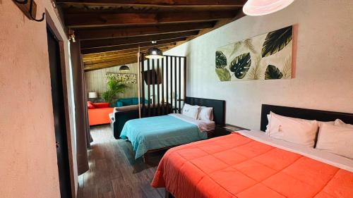 a bedroom with two beds and a living room at Hotel Villas Mariposas in Atlixco