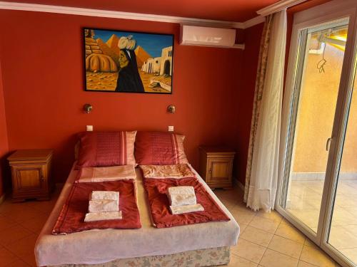 a bedroom with a bed with a painting on the wall at Apartman Jasmine in Csopak