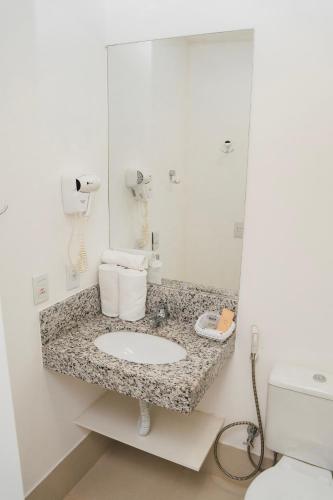 a bathroom with a sink and a mirror at Easy Hotel Cachoeiro de Itapemirim by Atlantica in Cachoeiro de Itapemirim