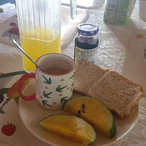 a plate of food with a cup of coffee and bread at Era's Garden Homestay in Catmon