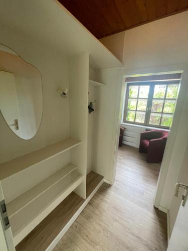 ein Zimmer mit einem Spiegel, einer Couch und einem Fenster in der Unterkunft Mariennest in Jever