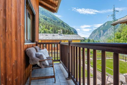 a rocking chair on a balcony with a view of mountains at The Haven Quiet Escape - Panoramic Terrace in Valtournenche