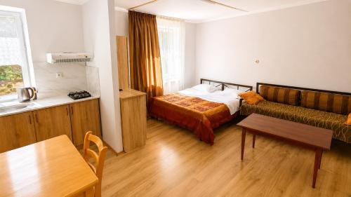 a bedroom with a bed and a table and a couch at Tuz House R3 in Bakuriani