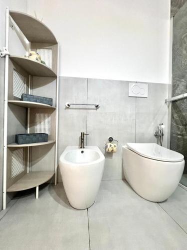 a bathroom with a tub and a toilet and a sink at La Pola House Cagliari in Cagliari