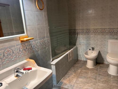 a bathroom with a sink and a toilet and a tub at Casa Rural Villacampa (Nocito) in Nocito