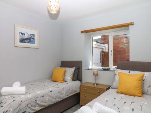 a bedroom with two beds and a window at The Milk Shed in Plymtree