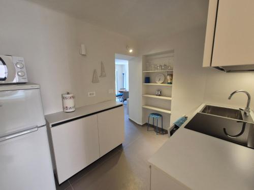 a kitchen with a white refrigerator and a sink at Rezzano 12 in Bonassola