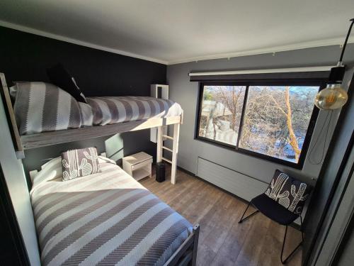 a room with two bunk beds and a window at Depto Premium Ski-in Ski-out Edificio Alerces-Nevados de Chillán in Nevados de Chillan