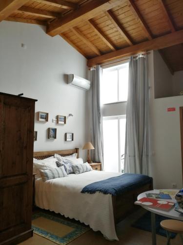 a bedroom with a bed and a large window at Bella's House in Évora