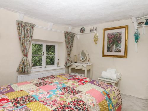 a bedroom with a colorful bed and a window at Mei's Cottage in Exeter