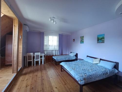 a room with two beds and a table in it at Фазенда in Bohuslav