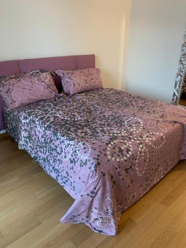 a purple bed with a purple comforter and pillows at Juwel am See in Castelletto di Brenzone