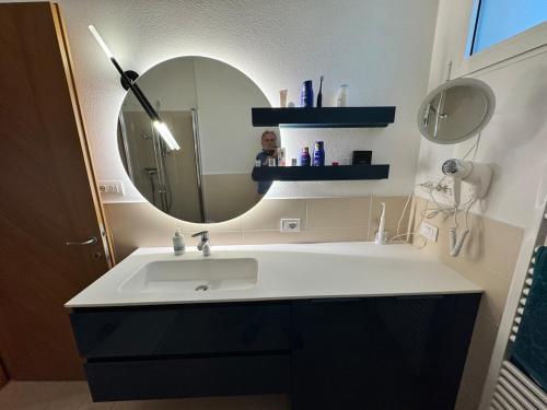 a bathroom with a sink and a mirror at Juwel am See in Castelletto di Brenzone